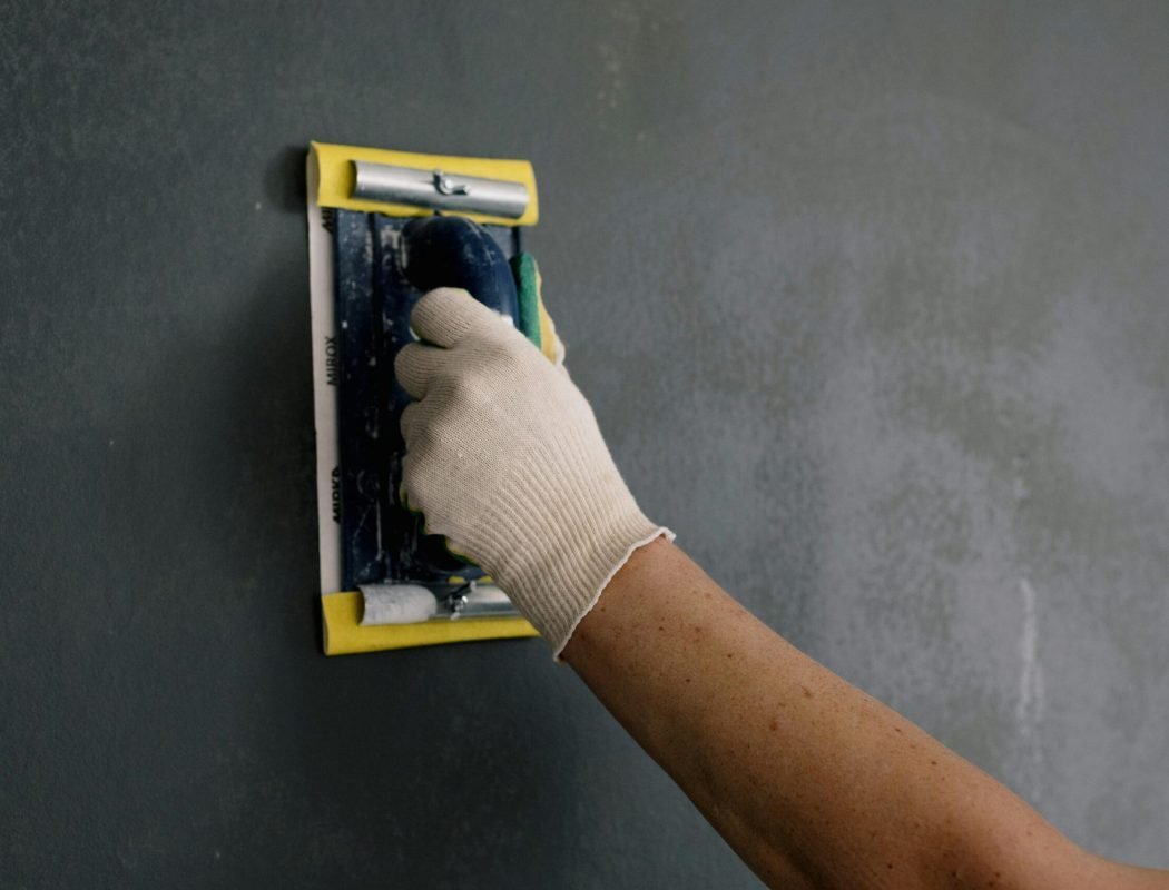 pexels-photo-5691613-5691613 Crop man scarpering gray wall in flat
